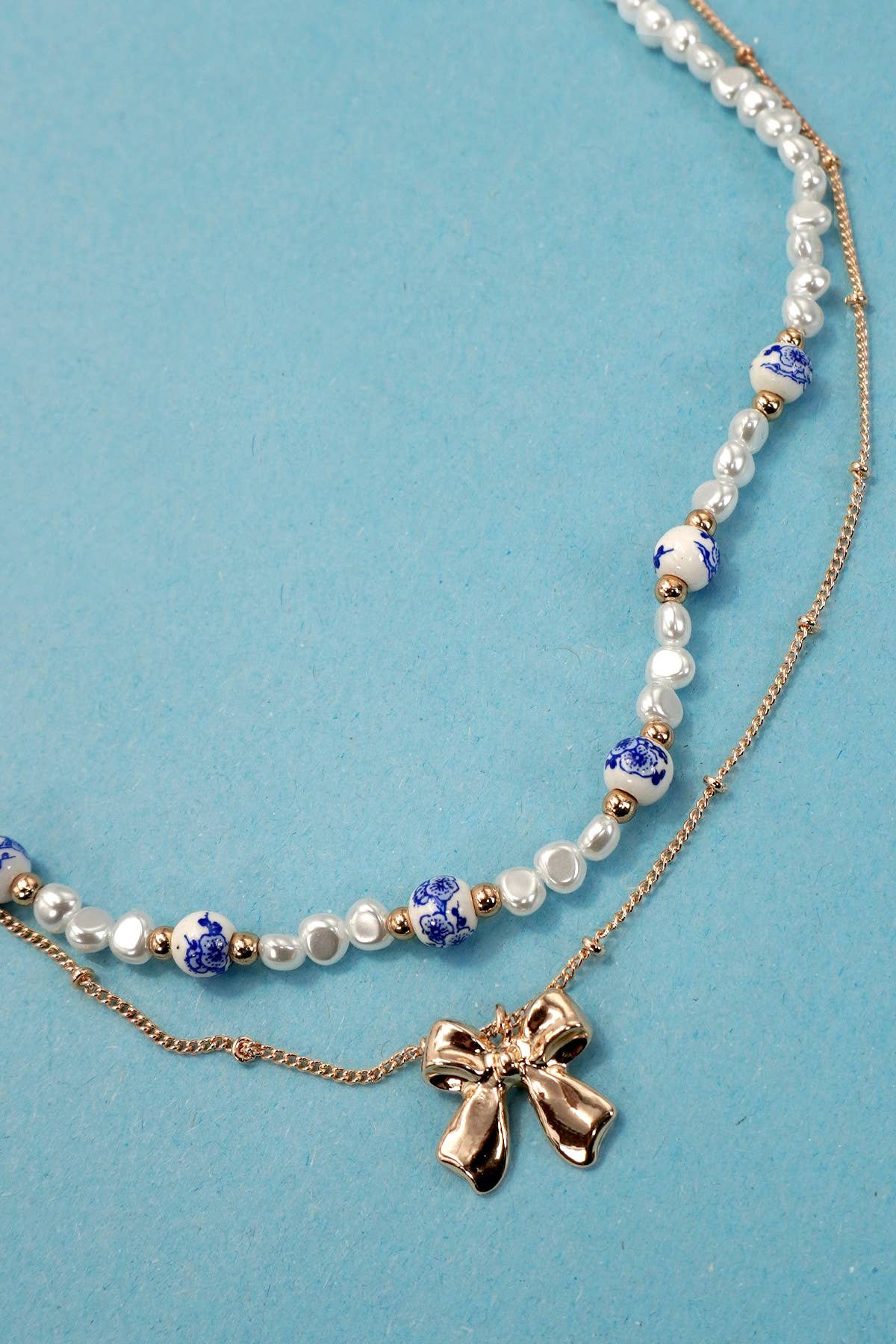 JOSSLYN by wall to wall - CERAMIC PORCELAIN PEARL BOW LAYER NECKLACE | 80N91555