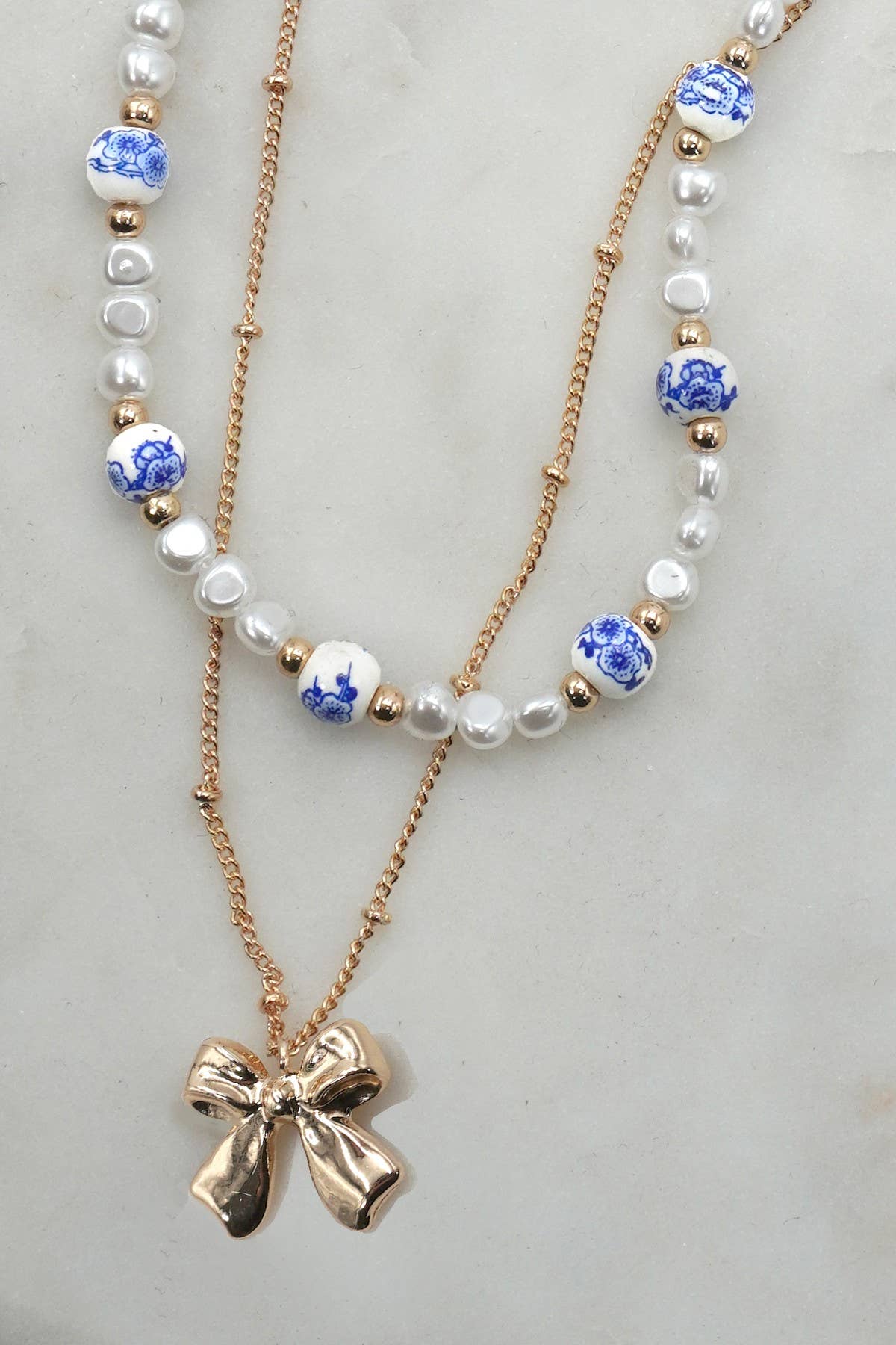 JOSSLYN by wall to wall - CERAMIC PORCELAIN PEARL BOW LAYER NECKLACE | 80N91555