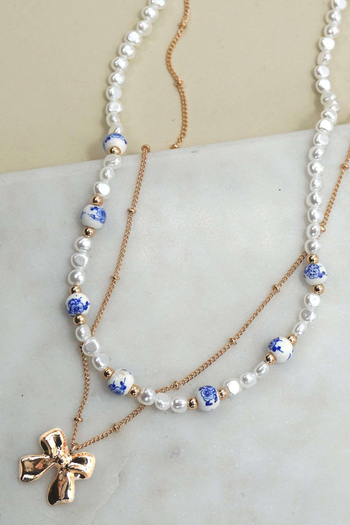 JOSSLYN by wall to wall - CERAMIC PORCELAIN PEARL BOW LAYER NECKLACE | 80N91555